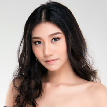 A young woman with long dark hair and bare shoulders looks directly at the camera against a neutral background.