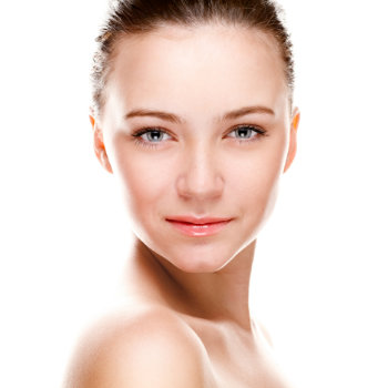 A portrait of a young woman with fair skin, blue eyes, and dark brown hair pulled back. She has a neutral expression and is looking directly at the camera against a white background.