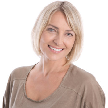 A woman with short blonde hair wearing a beige top smiles at the camera against a white background.