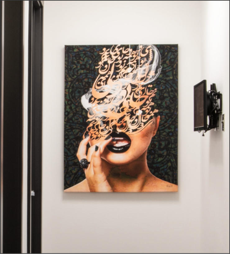 A hallway wall displays artwork depicting a woman's face with Arabic calligraphy obscuring her eyes, nose, and forehead, leaving her lips and fingers visible.